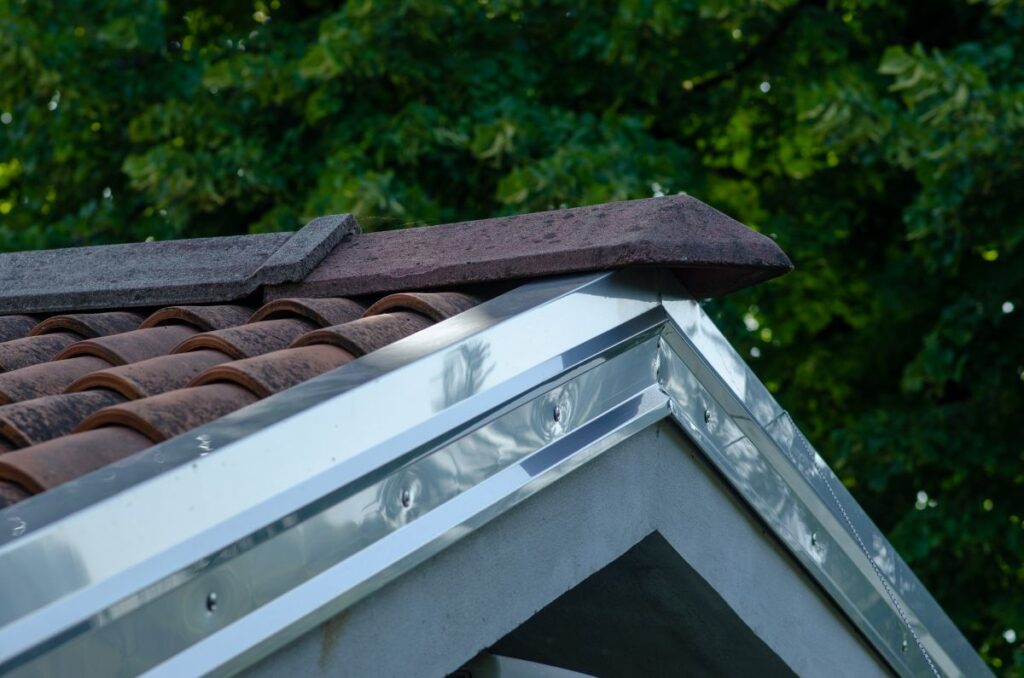 cornice with galvanized steel sheet, detail of the house on the part of the double-sided roof with ridge tiles