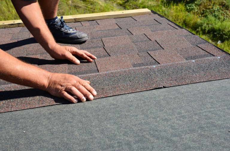 A person repairing a roof of a home in Woodbury